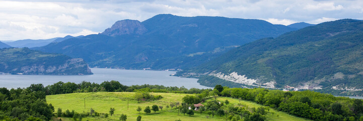 Serene emerald pastures stretch towards misty mountains, evoking Day of the Shepherd and Earth Day...