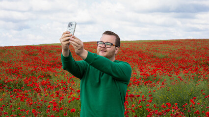 A Caucasian man captures a selfie amid a vast, whimsical poppy field, channeling the spirit of Poppy Day and digital nomad wanderlust