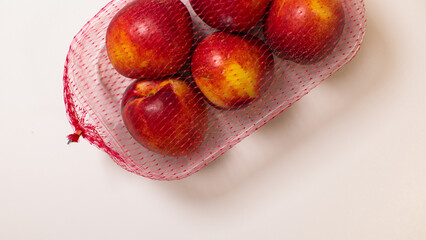 Vibrant nectarines nestled in rustic mesh, echoing midsummer epiphanies and Lammas harvest...