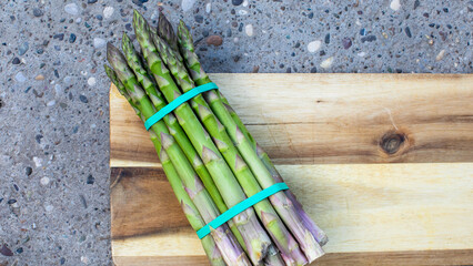 A bundle of asparagus spears whispers spring equinox renewal and farmer's market vibrance on wooden...