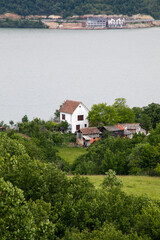 Tranquil riverside cottage nestled in lush greenery, evoking rustic retreat vibes, perfect for Earth Day or National Simplicity Day