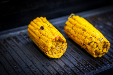 Grilled corn on electric grill close-up showing delicious roasted kernels with focus on taste and...