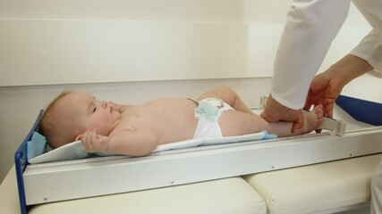 A doctor measures a baby's length during a routine medical examination. Healthcare for infants. Doctor Examining Baby