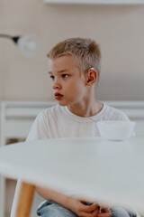 A boy with hearing aids enjoys a healthy breakfast, showcasing inclusive daily routines and...
