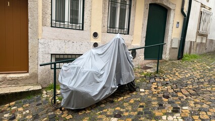 A shrouded bicycle whispers tales of urban hibernation, nestled in tranquil cobblestone alleys,...