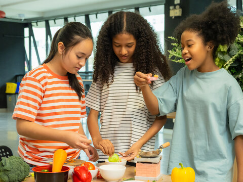 Kids children gril cute cooking group together teamwork play happy smile fun enjoy in class education learning clean culinary in mimi little kitchen preparing food with fresh vegetables on counter.