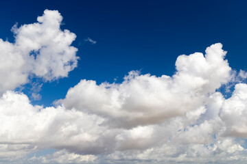 Fluffy White Clouds Against Deep Blue Sky