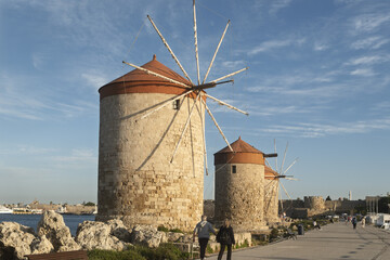 Old Windmill and ocean liner located at the Mandraki harbor in Rhodes Old Town, Greece