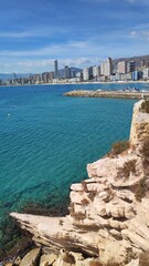 Coastal cityscape of Benidorm, Spain, featuring sandy beaches, clear blue water, and modern skyline. Popular Mediterranean destination known for tourism, sun, and vibrant seaside views.