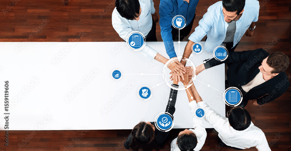 Leinwandbilder aerial view of a diverse group of professionals joining hands at a meeting table, representing teamw
