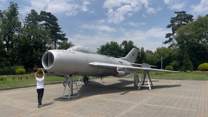 Vintage Soviet Fighter Jet on Outdoor Display with Child Observing
