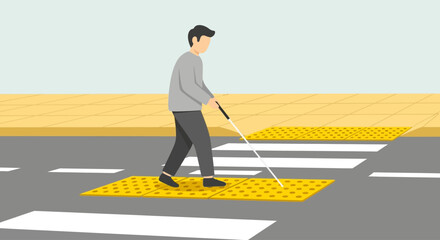 Person with a white cane crossing a pedestrian crossing with tactile paving.