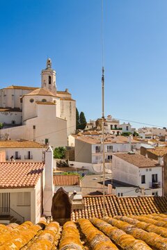 Charming narrow streets of Cadaqu&eacute;s, Spain, with white church on the hill, houses and vibrant blue sky, showcasing the historic Mediterranean coastal town&rsquo;s beauty and traditional architecture