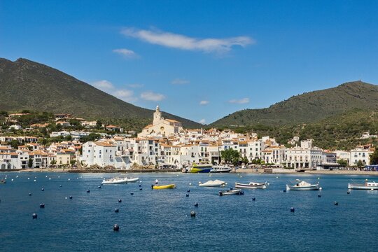 Charming Cadaqu&eacute;s, with small boats, white houses and vibrant blue sky, showcasing the historic Mediterranean coastal town&rsquo;s beauty and traditional architecture