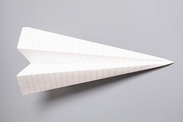 Origami paper airplane on gray background
