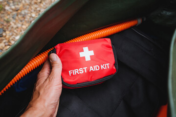 There is an individual who is currently holding a first aid kit firmly in their hand, indicating...