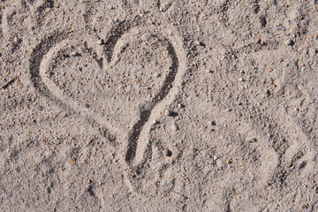 Heart drawn in the sand expressing love and romance on a sunny beach