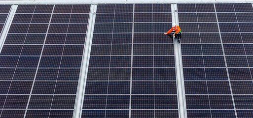 technician installs a large photovoltaic system on an industrial rooftop. ESG investment, and the...