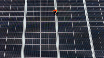 technician installs a large photovoltaic system on an industrial rooftop. ESG investment, and the...