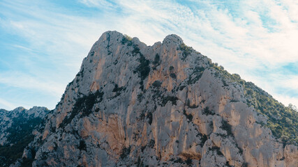 Fototapeta premium Steep rocky cliff in the French Prealps with trees growing along rugged stone formations