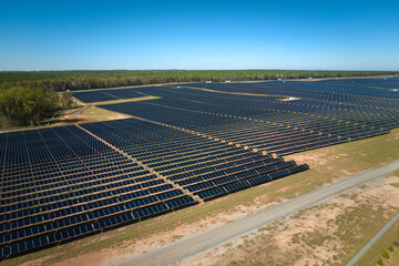 Aerial view of large sustainable electrical power plant with rows of solar photovoltaic panels for...
