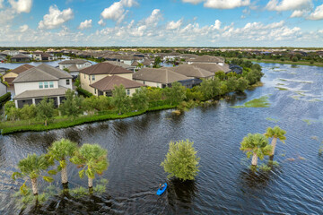 Flooded road with sunken car in surrounded with water Florida residential area. Consequences of...