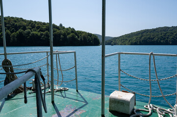 Railing of a boat on a lake with forest