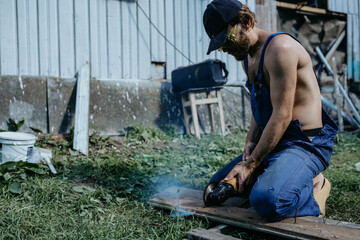 male builder restores old wooden house, replacing boards
