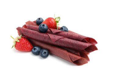 Tasty fruit leather rolls, strawberries and blueberries isolated on white
