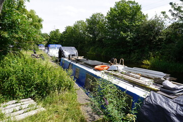 Nottinghamshire, England - June 20 2025: Tranquil canal scene with moored narrowboats and lush...