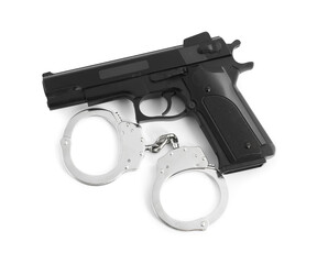 Gun and handcuffs on white background, top view. Police equipment