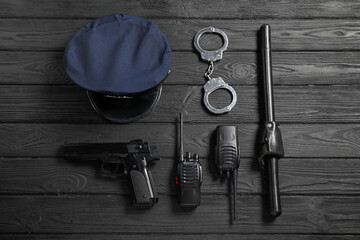 Different police equipment on black wooden table, flat lay