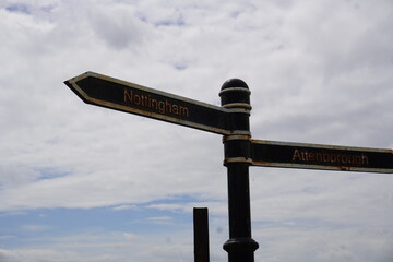 Nottingham, England - June 20 2025: Weathered, rustic signpost with directional signs for Nottingham and Attenborough on a cloudy day