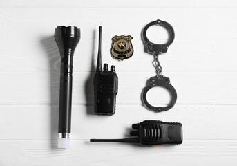 Different police equipment on white wooden table, flat lay