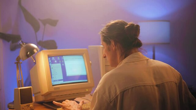 Man working and gaming on retro computer PC, IT engineer with vintage computer at home, using old fashion technology, close up of retro setup. 