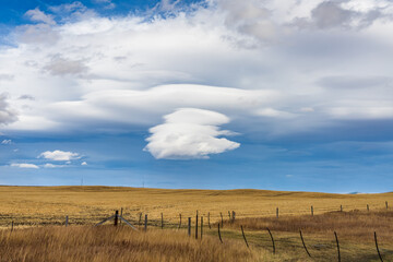 Cumulonimbus cloud in blue sky over country road in autumn season.