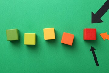 Maximum. Arrows pointing at colorful cubes on green background, flat lay