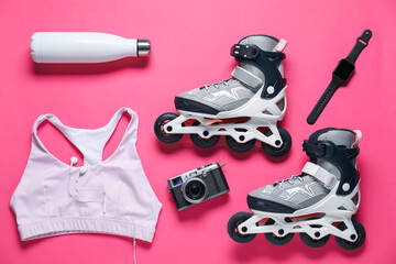 Flat lay composition with roller skates on pink background