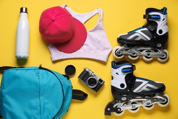 Flat lay composition with roller skates on yellow background