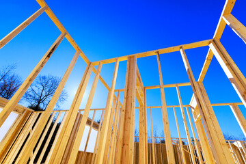 Obraz premium Wooden beam framework rises against during works day construction, showcasing modern building techniques.