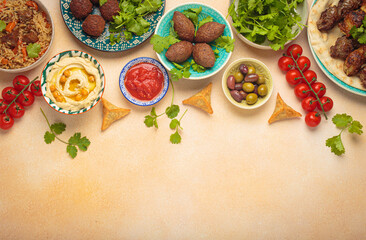 Border composition of middle eastern or Arab dishes and assorted meze on light beige background. Meat kebab, falafel, hummus, sambusak, rice, kibbeh, pita. Halal food. Lebanese cuisine, copy space
