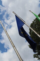 European union flag in the wind on a blue cloudy sky background 