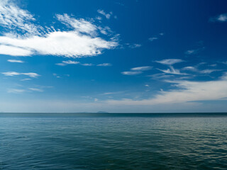 Serene tropical beach with crystal clear turquoise water, gentle waves, and a bright blue sky with fluffy white clouds. peaceful and relaxing summer scene perfect for panorama and travel concepts.