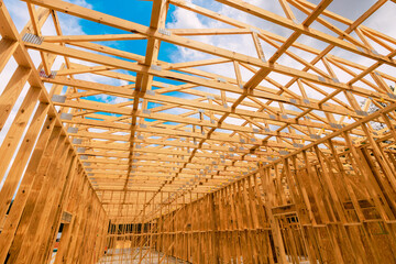 Wooden framing beams for building is visible at construction area under work site with scattered clouds.