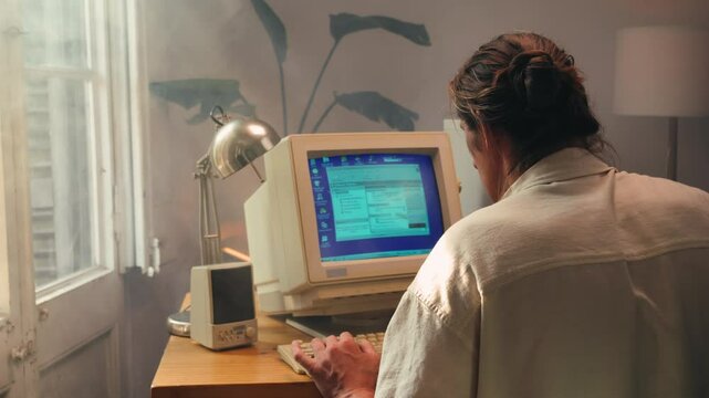 Man working and gaming on retro computer PC, IT engineer with vintage computer at home, using old fashion technology, close up of retro setup. 