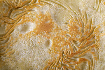 High-resolution macro image showing the detailed texture of a golden-brown cooked flatbread,...
