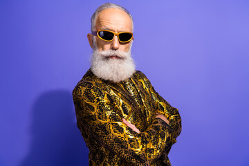 Stylish elderly gentleman wearing a vibrant patterned jacket and sunglasses posing confidently...