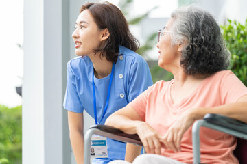 An empathetic caregiver crouches to listen to a senior woman in a wheelchair, demonstrating respect...