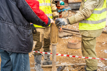 Man cutting and cleaning soil sample for laboratory analysis. Preparation of core material for geotechnical testing and scientific evaluatio