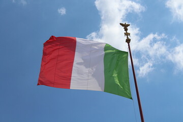 Italian flag in cloudy sky. waving in the sky. Italian flag in a wind on a cloudy blue sky background in Rome